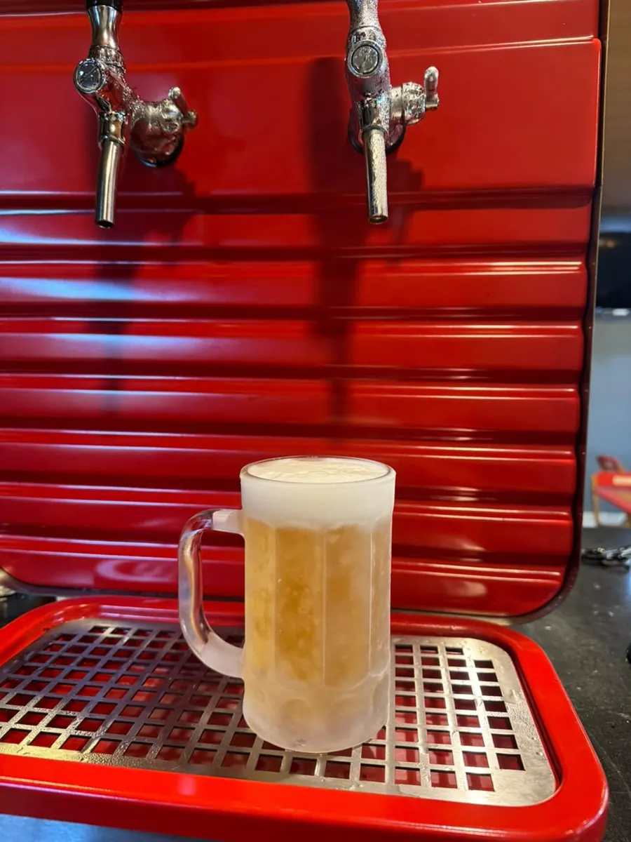 Caneco de chopp congelado na chopeira vermelha